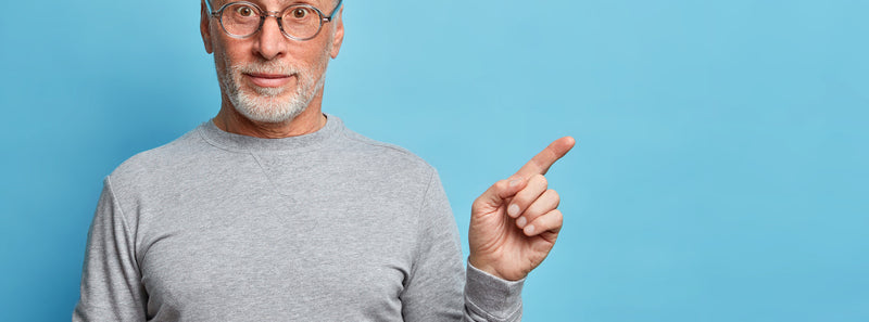 Senior pointant vers un espace pour illustrer un conseil ou une information